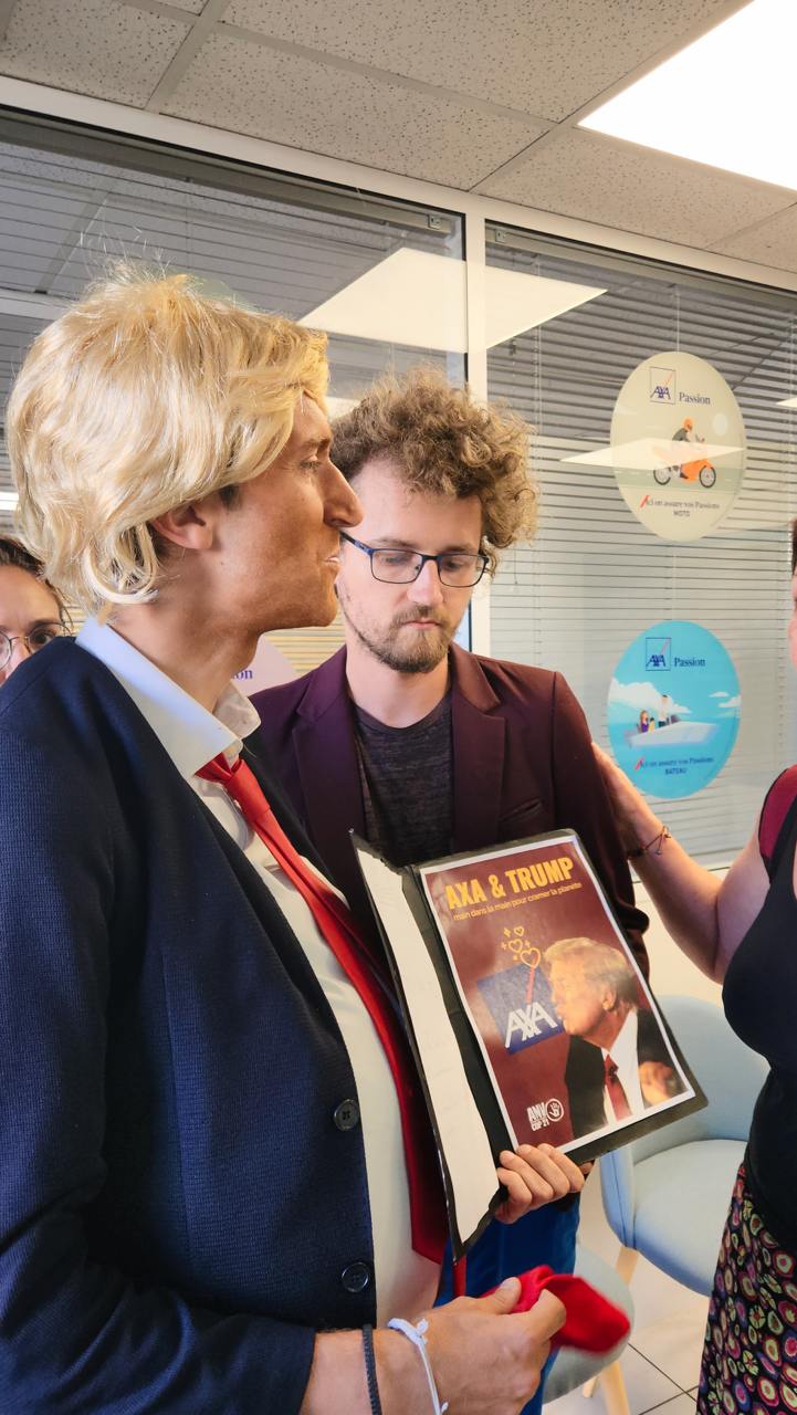 un activiste déguisé en Donald Trump parlant à une membre du personnel d’une agence AXA