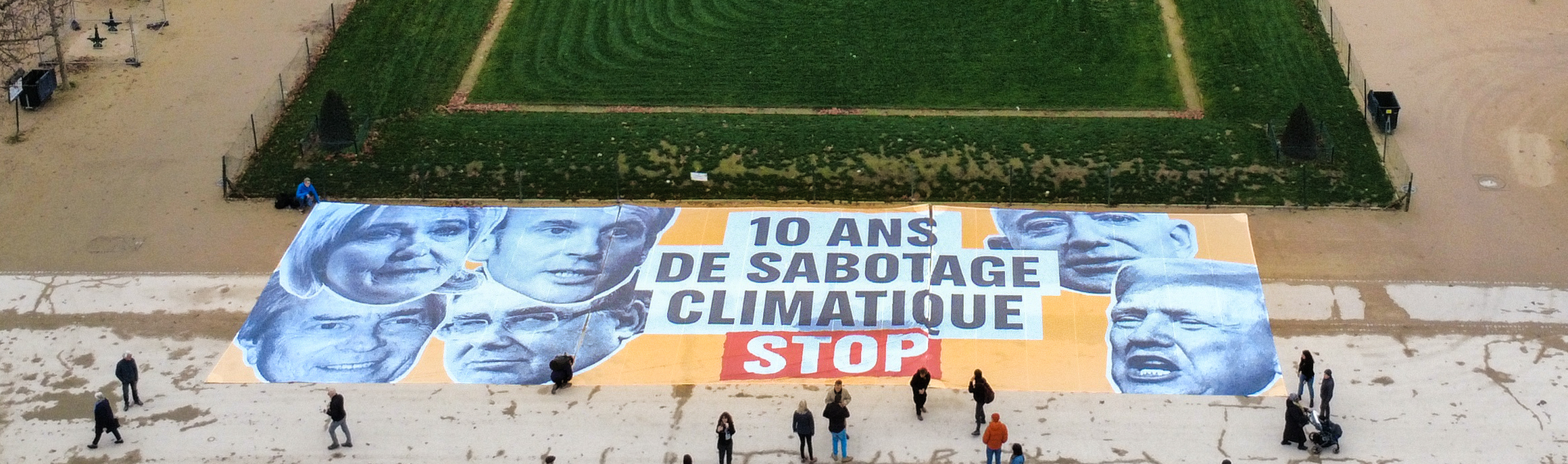 Une banderole géante est déployée sur le Champ-de-Mars. On y lis le message 
